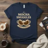 Mocha Snuggles Cozy & Caffeinated text with two coffee cups graphic on a navy t-shirt