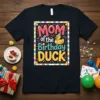 MOM of the Birthday DUCK text with a cute duck wearing a party hat graphic on a black t-shirt