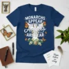 Monarchs Appear When Angels Are Near quote with monarch butterflies and floral accents on a navy blue t-shirt