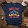 T-shirt with bold red text "MONSTER TRUCKS ARE MY JAM" above cartoon monster trucks driving over a dirt hill
