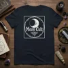 Dark t-shirt with "Moon Cult" text and a detailed moon graphic inside a circular, thorny vine border