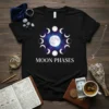 Black t-shirt with white text "MOON PHASES" and a circular graphic of the full moon and its phases