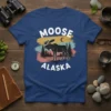 Vintage Moose Alaska t-shirt design with a silhouette of a moose in a forest landscape and the text "MOOSE ALASKA"