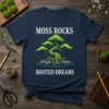 Moss Rocks Rooted Dreams t-shirt with a stylized bonsai tree on grey rocks in water, white text above and below