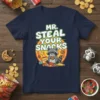 Mr. Steal Your Snacks t-shirt design with a cute raccoon holding a cookie and surrounded by snacks