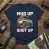 Mud Up Or Shut Up T-Shirt featuring a lifted Jeep graphic with mud splatters, bold white text