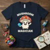 Mushroom Magician text above a cute cartoon mushroom character holding a blue orb, on a navy t-shirt