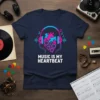 Music Is My Heartbeat T-Shirt featuring a stylized heart with headphones and speakers, white text on navy blue fabric