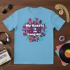 My Aura is is so Gangster quote on a light blue t-shirt with colorful geometric background and gold chain detail