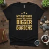 Black t-shirt with gold text quote "My Blessings Are Bigger Than My Burdens" and three stars