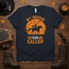 My Broom Can Gallop Halloween t-shirt with a witch riding a horse silhouette against an orange moon and bats