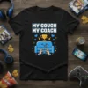 My Couch My Coach text with a cute blue couch character holding a game controller on a black t-shirt