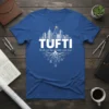 Blue t-shirt with white text "TUFTI My dream has already come true" and a cityscape graphic above tree roots