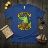 My Money My Swamp t-shirt design with a smiling alligator, treasure chest, and falling coins on a blue shirt