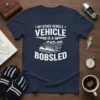 Navy blue t-shirt with white text "My Other Vehicle Is A Bobsled" and a graphic of a bobsled team