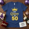 Navy blue t-shirt with yellow text "My Queen Is Is 50" and a yellow crown graphic, celebrating a 50th birthday