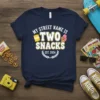 Navy t-shirt with "MY STREET NAME IS TWO SNACKS EST. 2024" text, chips bag, and ice cream graphic