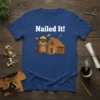Nailed It! quote with a cartoon beaver holding a hammer next to a log cabin on a blue t-shirt