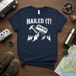 Nailed It! camping quote t-shirt with a graphic of a camper on a mountain peak and a hammer
