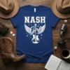 Nash Girl t-shirt design featuring white typography, wings, an acoustic guitar with a cityscape, and musical notes on a navy