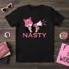 Black t-shirt with the word "NASTY" in pink, featuring a graphic of hands holding a megaphone and wearing a pink