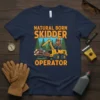 Natural Born Skidder Operator t-shirt design featuring a beaver in a hard hat operating a logging skidder machine with logs