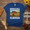 Nebraska Farmer t-shirt design featuring a combine harvester in a cornfield with a barn and silo under a sunny sky