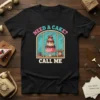 Need A Cake? Call Me T-Shirt featuring a retro-style illustration of a multi-tiered cake in a window with a vintage