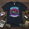 Retro arcade t-shirt design with "NEVER FORGET" text, featuring an 80s-style TV screen with arcade cabinet, planets, and comets