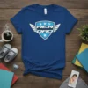 Blue t-shirt with white and light blue "New Dad" shield graphic featuring wings, baby bottle, and stars