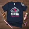 Navy blue t-shirt with white and pink "Ninja Princess" text and a silhouette of a ninja within a crown graphic
