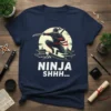 Ninja Shhh... text with a jumping ninja graphic and Japanese temple silhouettes on a navy blue t-shirt
