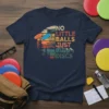 Disc golf t-shirt with "No Little Balls Just Big Discs" text and vintage sunset graphic featuring a basket and flying