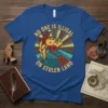 Blue t-shirt with "No One Is Illegal On Stolen Land" text and a graphic of Earth with a feather and