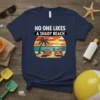 Navy t-shirt with "NO ONE LIKES A SHADY BEACH" text and cartoon crabs on a beach sunset graphic