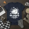 NO PANTS CLUB EST. 2023 graphic t-shirt featuring a character relaxing on a couch with snacks and remote