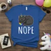 Grumpy black cat with unicorn horn and rainbow saying Nope on a blue t-shirt