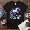 Black t-shirt with "Normal People Scare Me" text and a purple unicorn graphic, stars, and moons