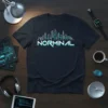 Black t-shirt with a white and teal outline of a cityscape and the word NORMAL in bold letters below