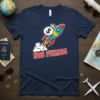 Navy blue t-shirt with "Nos Fuimos" text and a cartoon rocket carrying a money bag, symbolizing travel and departure