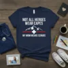 Navy t-shirt with white text "NOT ALL HEROES WEAR CAPES MY MOM WEARS SCRUBS" featuring mountains and a red line