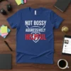 A blue t-shirt with the words "NOT BOSSY AGGRESSIVELY HELPFUL" printed in white and red
