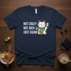 Navy t-shirt with white text "NOT CRAZY NOT RICH JUST ASIAN" and a cartoon lucky cat graphic