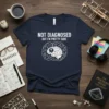 Navy t-shirt with white text "NOT DIAGNOSED BUT I'M PRETTY SURE" and a white brain graphic surrounded by icons, representing