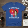 Not Sisters By Blood But Sisters By Heart quote on a blue t-shirt with two women holding hands in front