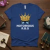 Blue t-shirt with "NOTORIOUS R.B.G." text, a golden crown, and blue tinted glasses graphic