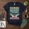 Navy blue t-shirt with "NURSE NURSE Nurse NURSE" text design, caduceus symbol, and wings