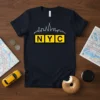 Navy t-shirt featuring a white outline of the New York City skyline above yellow squares with black lettering spelling NYC