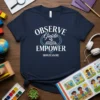 OBSERVE Guide EMPOWER MONTESSORI text design on a navy blue t-shirt with an open book and sprout graphic