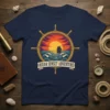 Ocean Sunset Adventure t-shirt design featuring a ship sailing on the ocean at sunset, framed by a ship's wheel